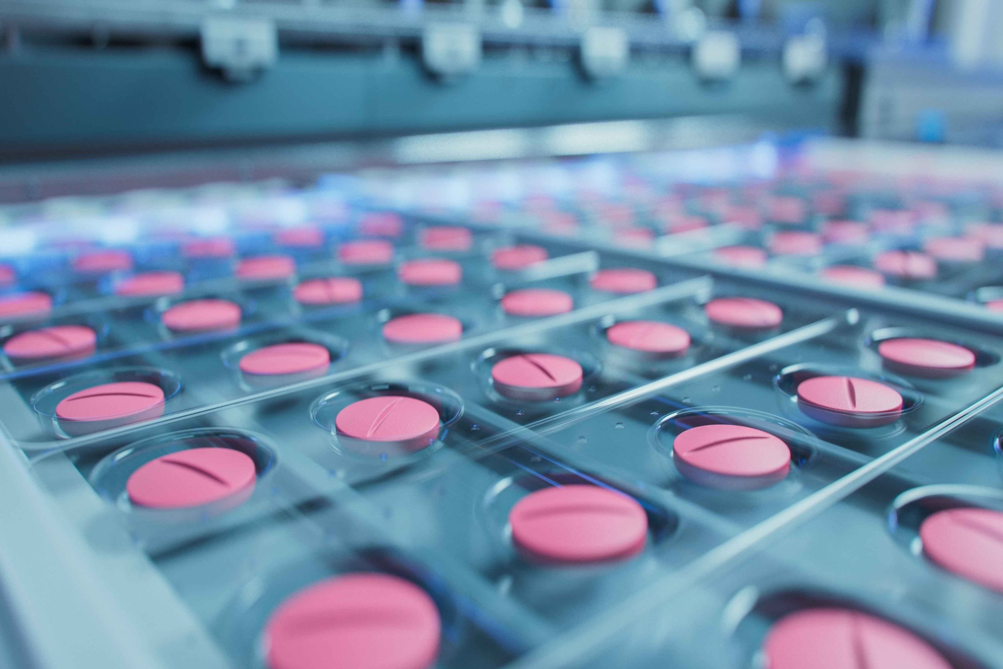 Macro Shot of Pink Pills During Production and Packing Process on Modern Pharmaceutical Factory. Medical Drug Manufacturing.